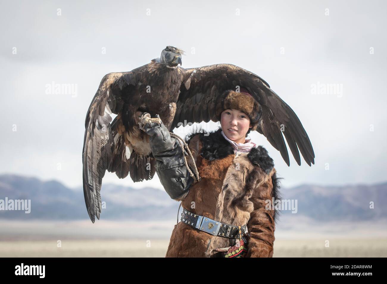 Giovane cacciatore di aquile con la sua aquila femminile, Olgii, Mongolia Foto Stock