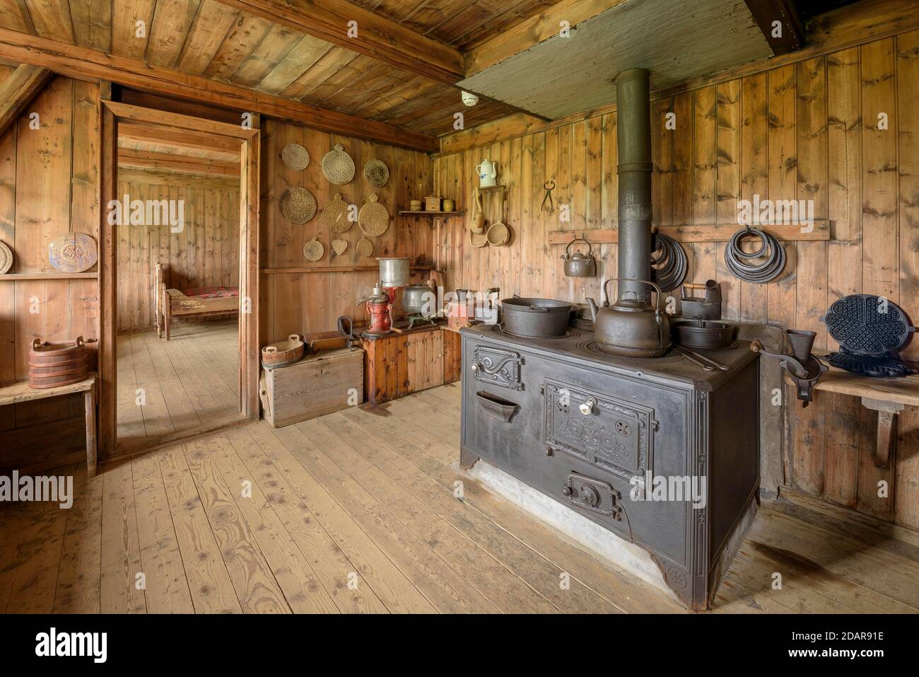 Vista interna della cucina storica con vecchio forno, padelle, pentole, bollitore per il tè e waffle ferro da stiro sul cortile della torba, casa di cova insediamento Grenjadarstadur Foto Stock