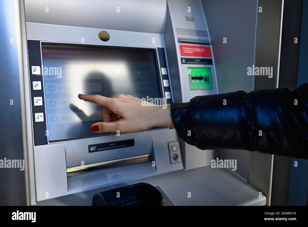 Donna che scrive sul touch screen di un bancomat di una banca di risparmio, Waiblingen, Baden-Wuerttemberg, Germania Foto Stock
