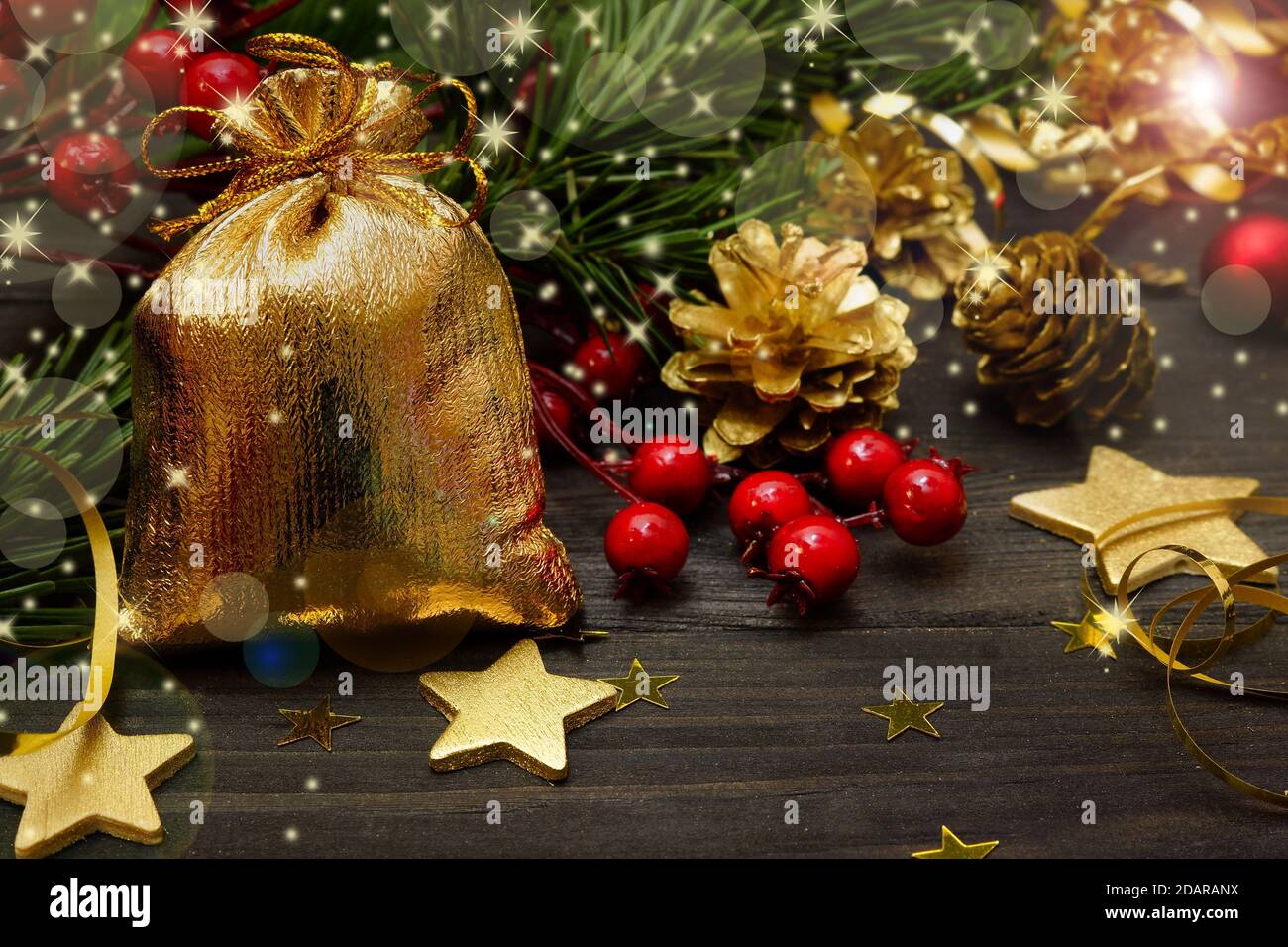 Carta anno nuovo. Borsa d'oro con regali e decorazioni dell'albero di Natale sul tavolo nero Foto Stock