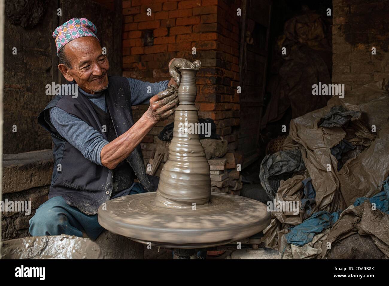 Un vasaio che lavora al suo pannello di vasaio, mercato della ceramica, Bhaktapur, valle di Kathmandu, Nepal Foto Stock