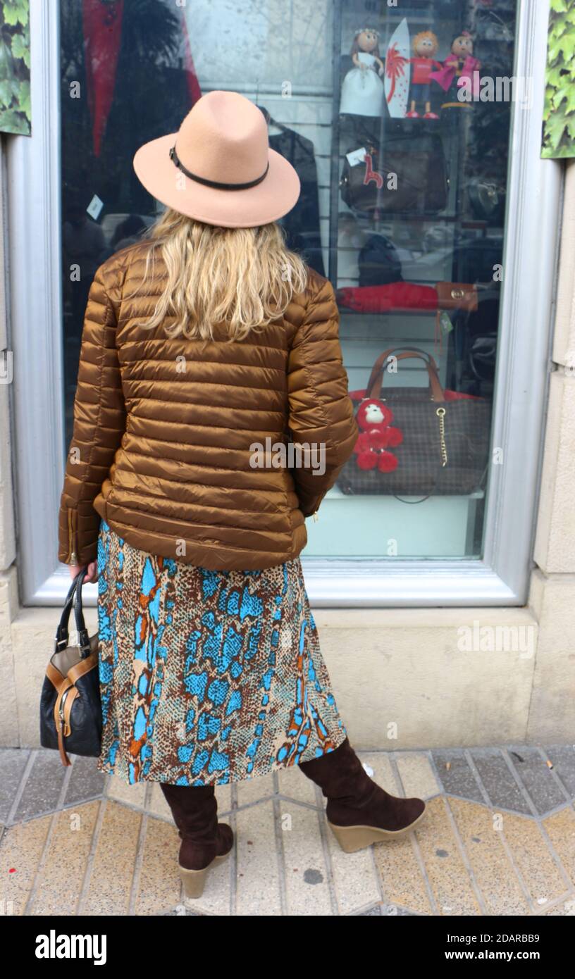 Donna bionda in giacca a cappello abito lungo e stivali guardando una  vetrina Sardinero Santander Cantabria Spagna Foto stock - Alamy