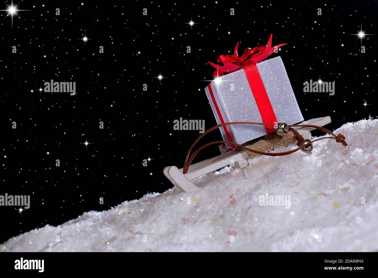 Slitta con un regalo per andare con le montagne innevate. Cielo stellato Foto Stock