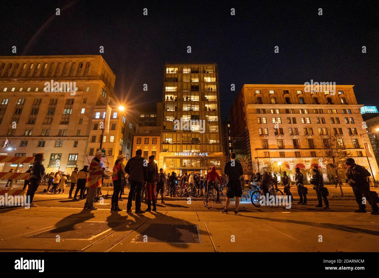 Washington, Stati Uniti. 14 novembre 2020. Gli spettatori nelle finestre dell'Hyatt Place Hotel guardano verso il basso alla folla di alcuni "MYLION MAGA marchers" e dimostranti anti anti anti di Trump dopo la loro marcia alla Corte Suprema di Washington, DC, sabato 14 novembre 2020. Foto di Ken Cedeno/UPI Credit: UPI/Alamy Live News Foto Stock