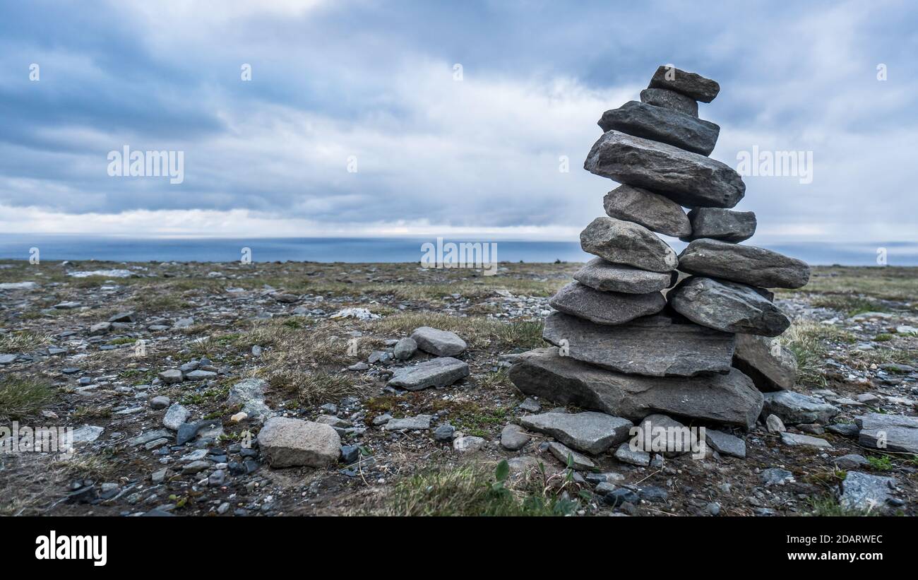 Buona fortuna cairns fatto di pietre in Norvegia sotto drammatico cielo Foto Stock