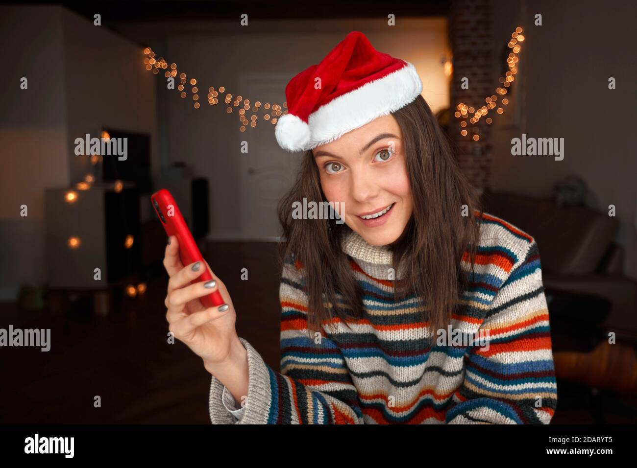 Donna di festa che guarda la fotocamera che tiene il primo piano dello smartphone Foto Stock