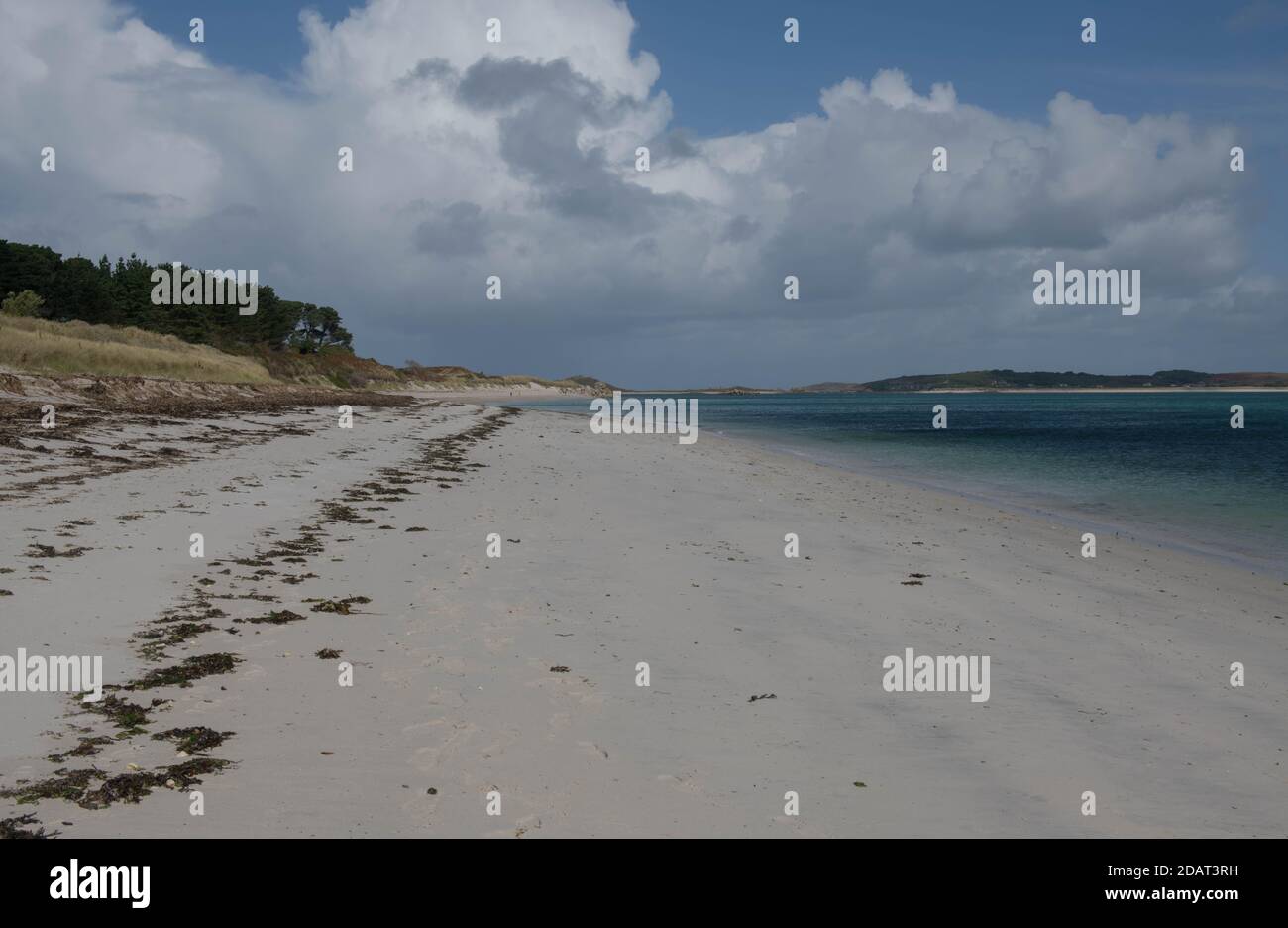 Paesaggio panoramico sulla spiaggia di Pentle Derseted con un suggestivo sfondo di cielo blu nuvoloso sull'isola di Tresco nelle isole di Scilly, Inghilterra, Regno Unito Foto Stock