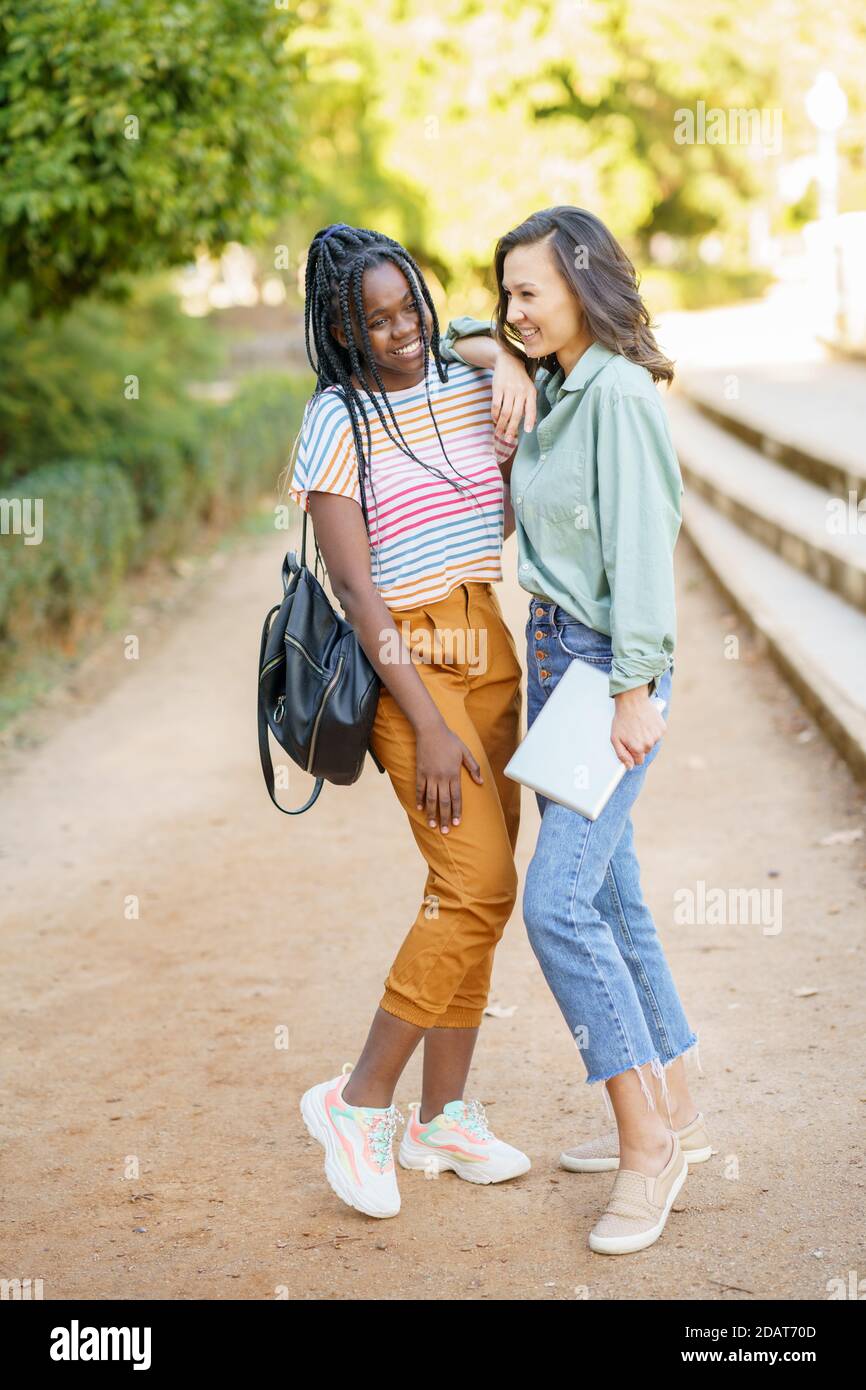 Due ragazze multietniche che si posano insieme a un colorato abbigliamento casual Foto Stock