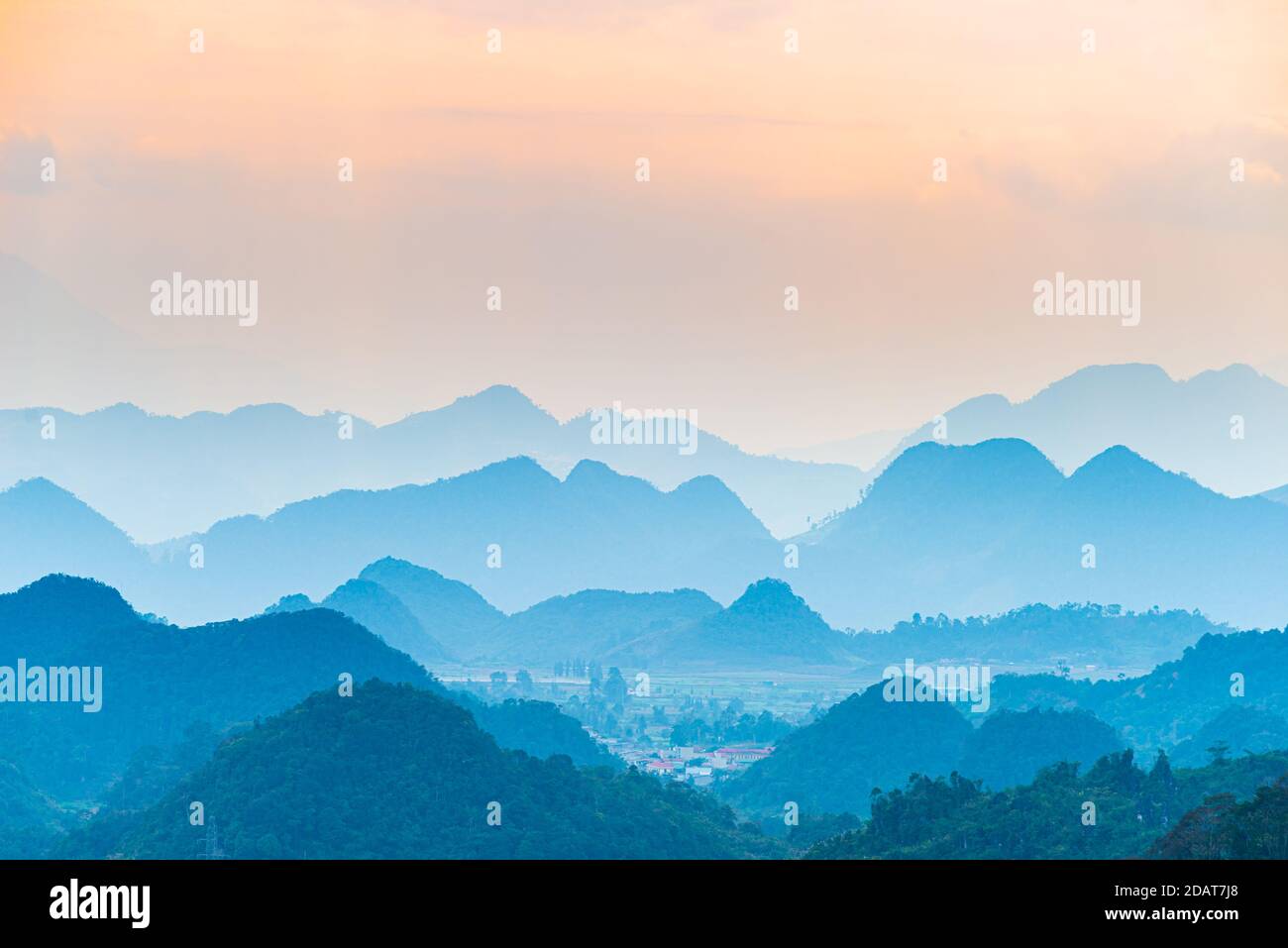 Ha Giang carst geopark paesaggio in Vietnam del Nord. Silhouette di montagna splendido paesaggio nebbia e nebbia nelle valli al tramonto. Ha Giang giro in moto Foto Stock