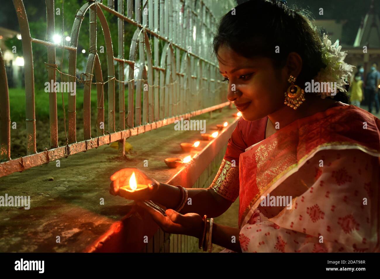 Dhaka, Bangladesh. 14 novembre 2020. Una donna accende una lampada per celebrare Diwali, il Festival indù delle luci, a Dhaka, Bangladesh, il 14 novembre 2020. La comunità indù del Bangladesh ha celebrato Diwali nella capitale Dhaka e altrove nel paese sabato sera. Credit: Salim/Xinhua/Alamy Live News Foto Stock