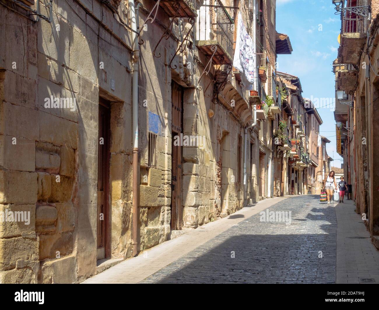 Una madre e suo figlio camminano a casa dopo lo shopping in Calle Mayor alta - Navarrete, la Rioja, Spagna Foto Stock