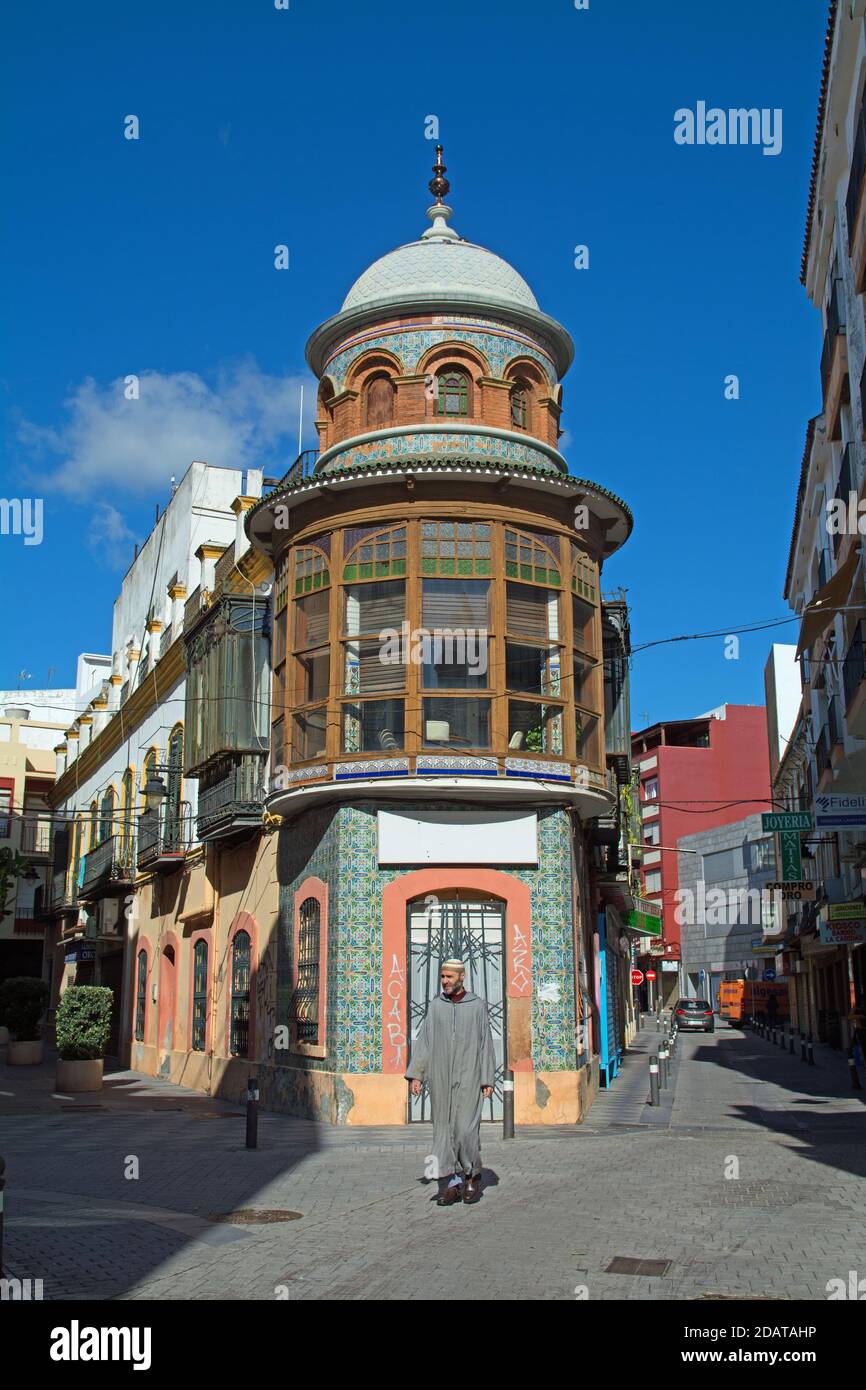 Un vecchio edificio con influenza moresca ad Algeciras (provincia di Cadice, Andalusia, Spagna) con un uomo nordafricano in abito tradizionale che passa. Foto Stock