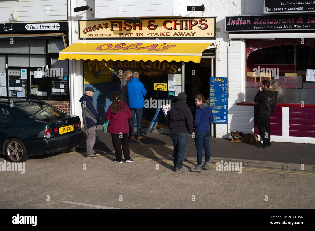 Oscar's fish and chips a Littlehampton, un popolare ristorante da asporto con una coda di clienti. Foto Stock