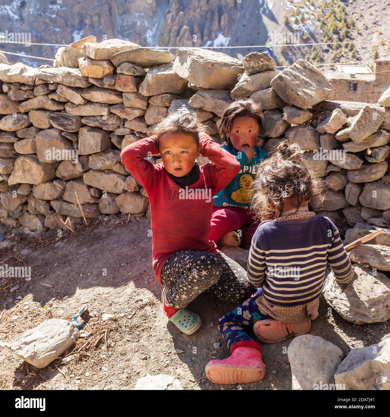 Manang, Nepal - 11 novembre 2015: Tre bambini nepalesi che giocano sulla strada del villaggio Foto Stock