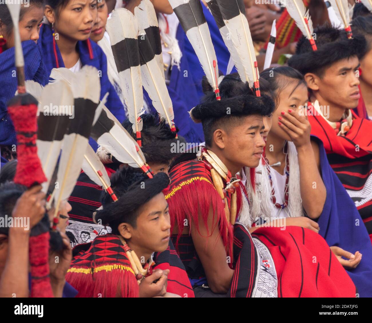 I ragazzi e le ragazze di Naga giovani si siedono insieme indossando l'abito colorato E scialle in Kisama Heritage Village a Nagaland India ON 3 dicembre 2016 Foto Stock