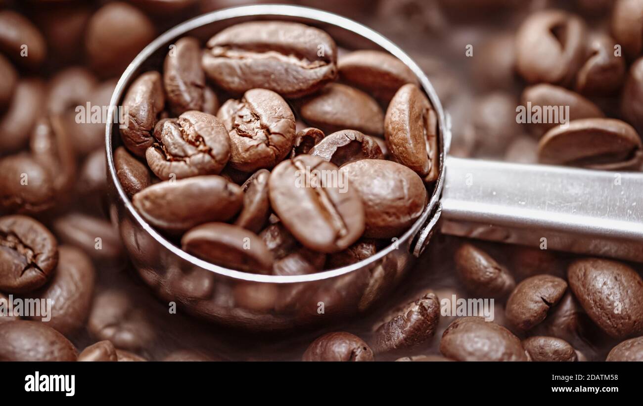 Primo piano di semi di caffè. I chicchi di caffè profumati sono il fumo arrosto proveniente dai chicchi di caffè. Foto Stock