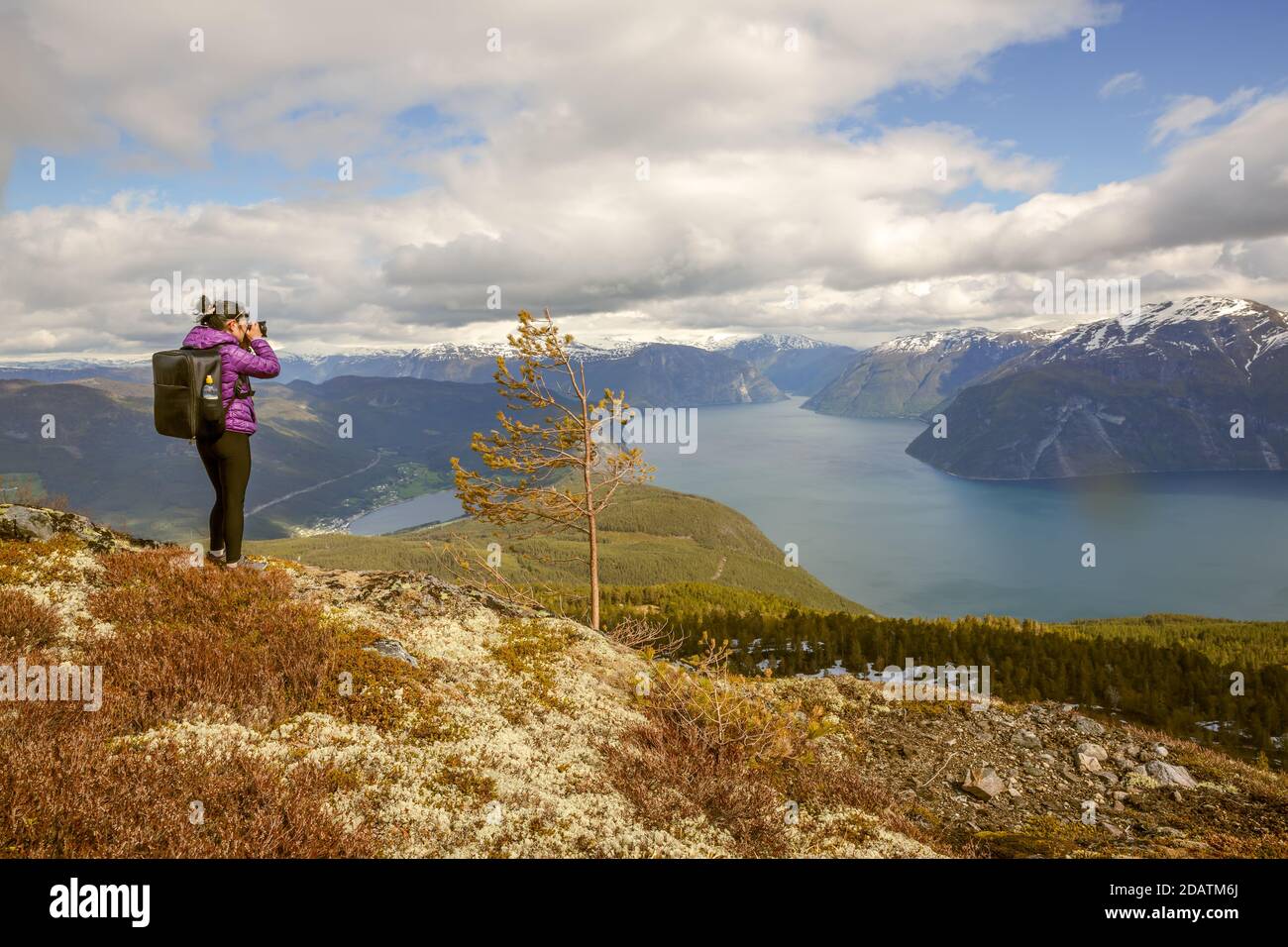 Fotografo di natura turistico con fotocamera germogli mentre permanente sulla cima della montagna. La bellissima natura della Norvegia. Foto Stock