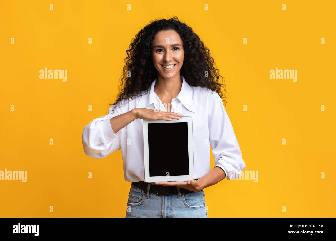 Bella donna sorridente Holding Digital Tablet con schermo nero vuoto Foto Stock