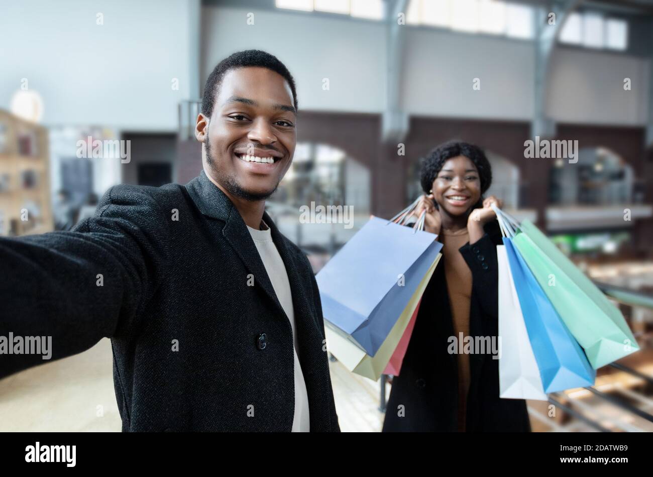Coppia godere di tempo libero acquistare e tenere molte borse con gli acquisti, a piedi nel centro commerciale Foto Stock