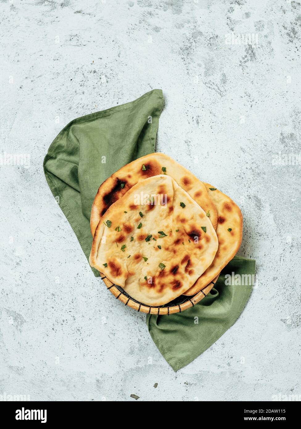 Pane fresco naan su fondo grigio cemento con spazio copia. Vista dall'alto di diversi piatti naan perfetti. Verticale Foto Stock