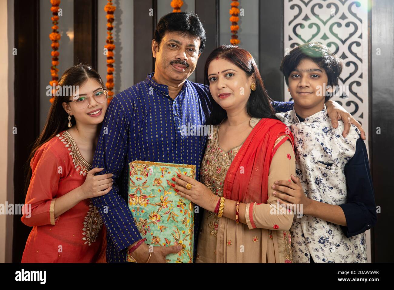 Una famiglia indiana di quattro persone in posa per una foto, genitori con bambini. Foto Stock