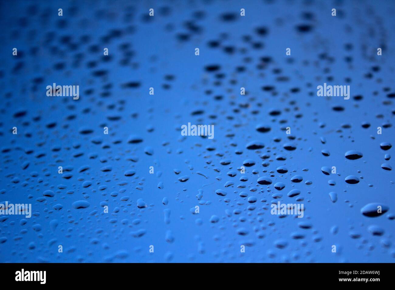 Gocce d'acqua sul bicchiere. Astratto sfondo blu testurizzato. Foto Stock