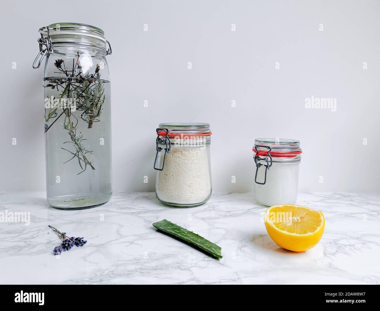 Set di prodotti per la pulizia fai da te come ammorbidente per tessuti e detersivo per bucato con ingredienti naturali come lavanda, aloe vera e limone Foto Stock