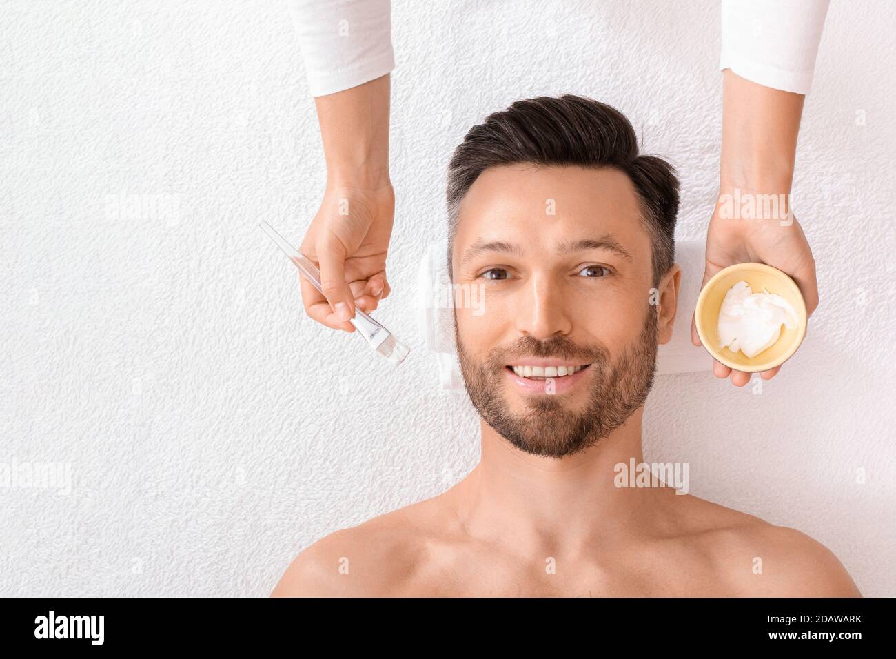 Vista dall'alto dell'uomo felice con maschera sul bianco Foto Stock
