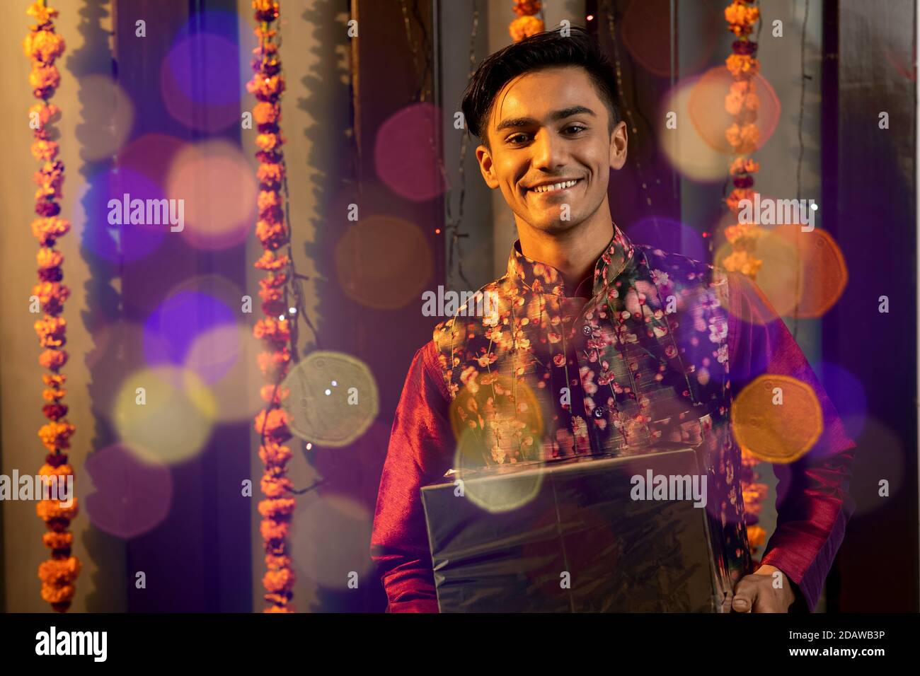 Ritratto di un indiano che tiene una scatola di regali in occasione di festa di Diwali. Celebrazioni a casa. Foto Stock