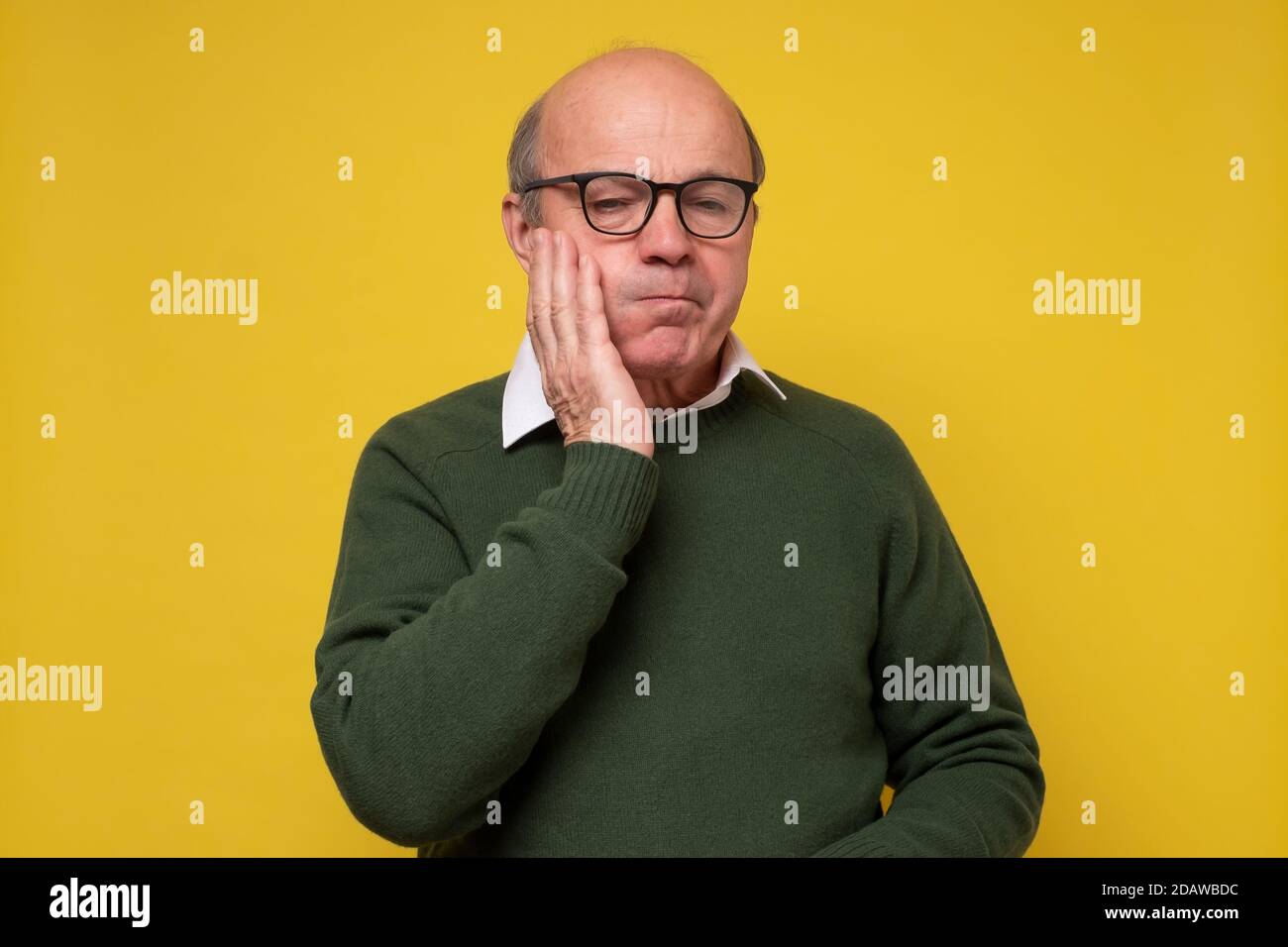 Uomo ispanico con mal di denti su sfondo giallo Foto Stock