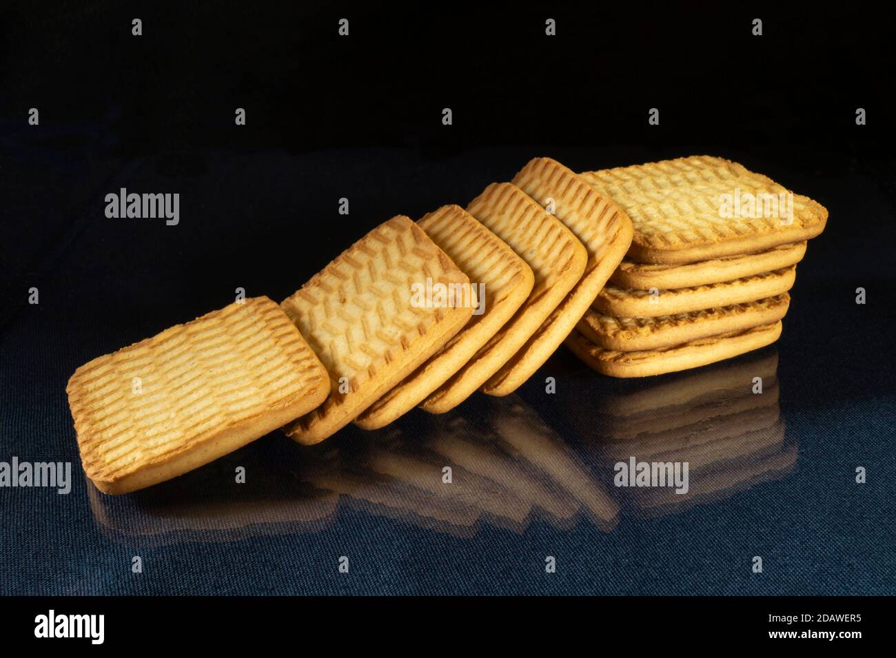 Il biscotto dolce al tè sul tavolo con riflessione. Prodotti dell'alimentazione su sfondo nero Foto Stock