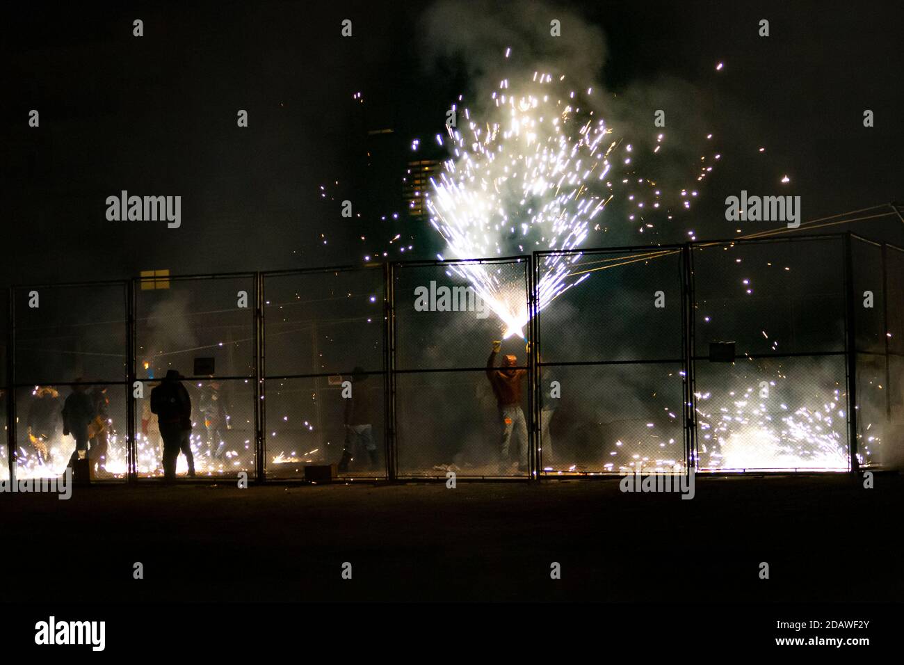 Fuochi d'artificio di un festival tradizionale di Valencia chiamato 'cordá'. Uomini bloccati in una gabbia di metallo che spara i firecrackers Foto Stock