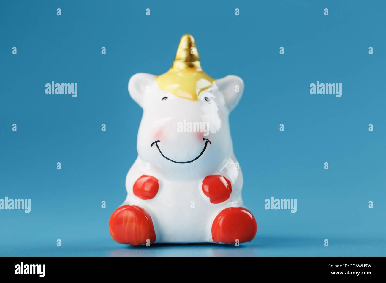 Figurina Unicorn su sfondo blu con spazio libero. Foto Stock