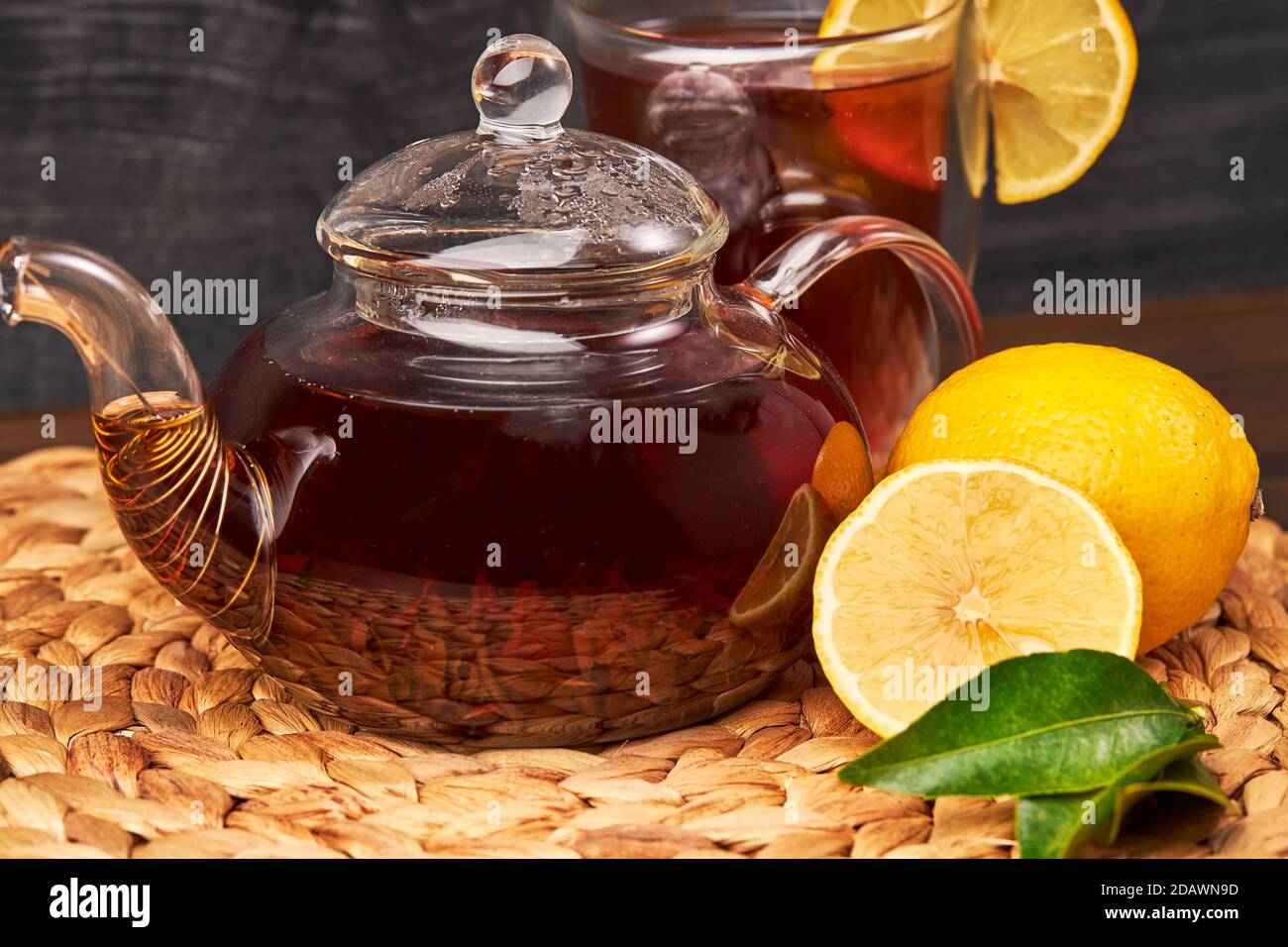 tazza di tè, teiera di vetro, limone su un tavolo di legno Foto Stock