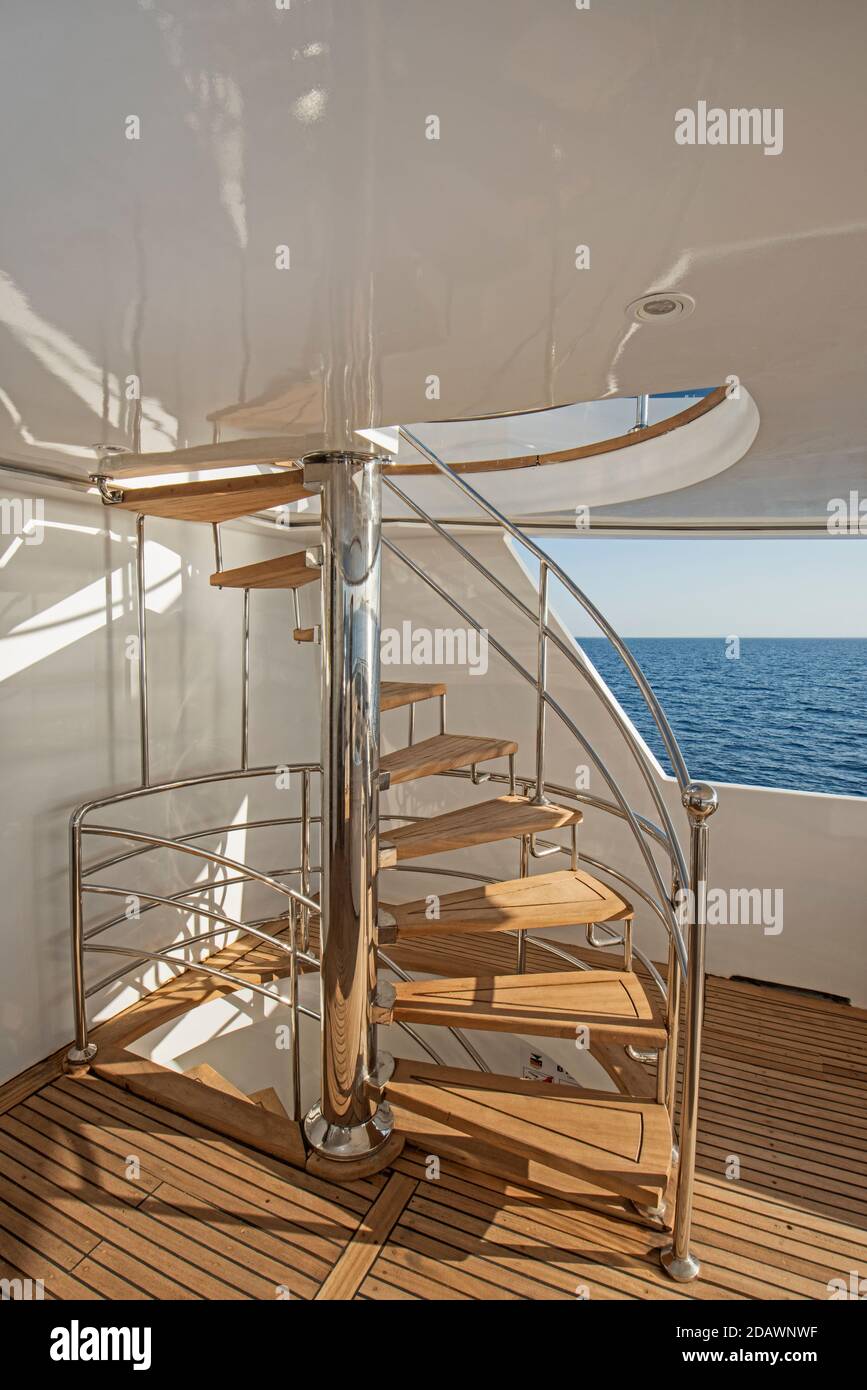 Curvi in legno scala a spirale su una zona per prendere il sole di gran lusso yacht a motore Foto Stock