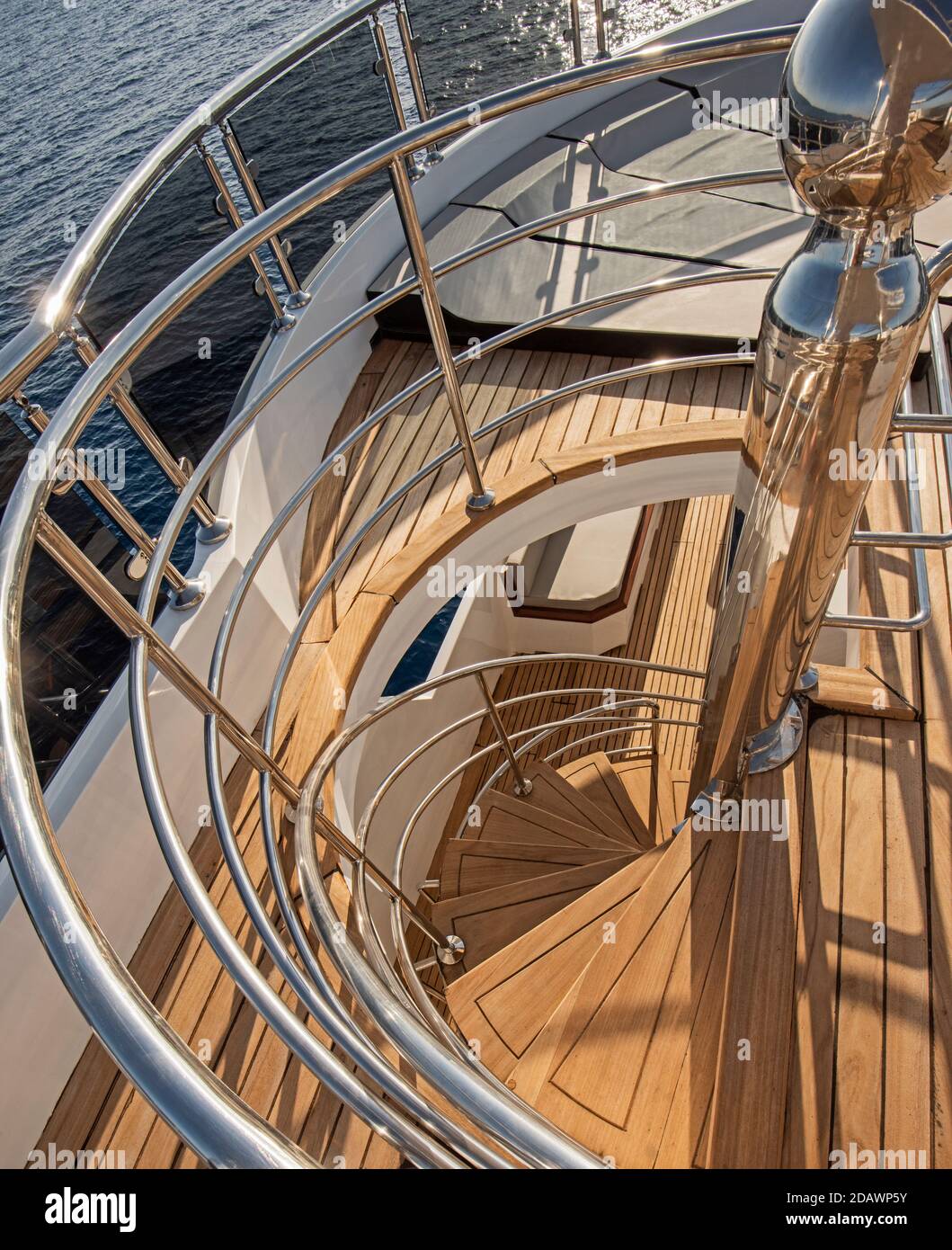 Vista astratta della scala a chiocciola curva in legno sull'area del solarium di grande yacht a motore di lusso Foto Stock