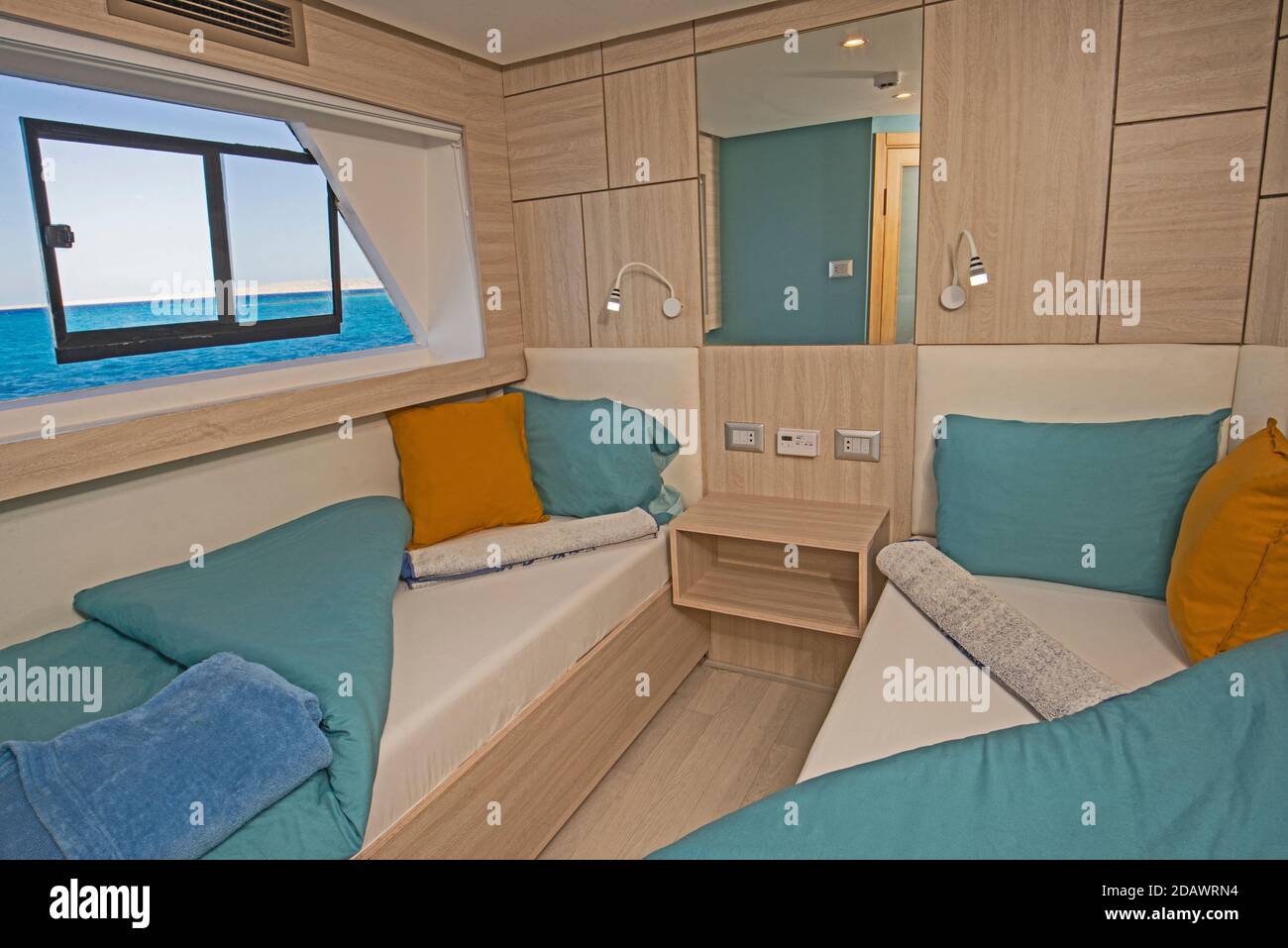 Interno cabina camera da letto su yacht a vela di lusso con letti gemelli letti e vista mare Foto Stock