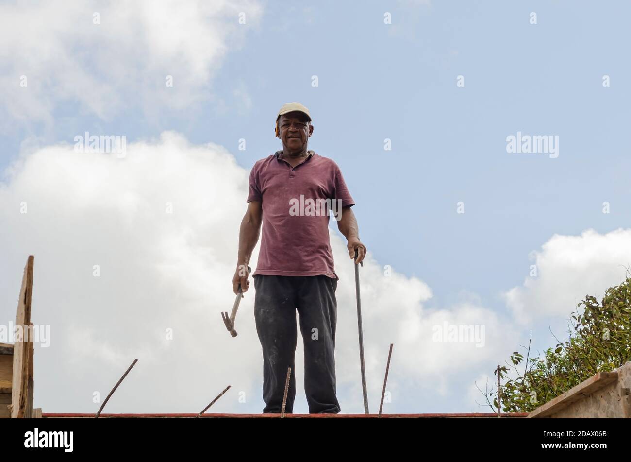 Tradesman in piedi sulla cima DI UN edificio Foto Stock