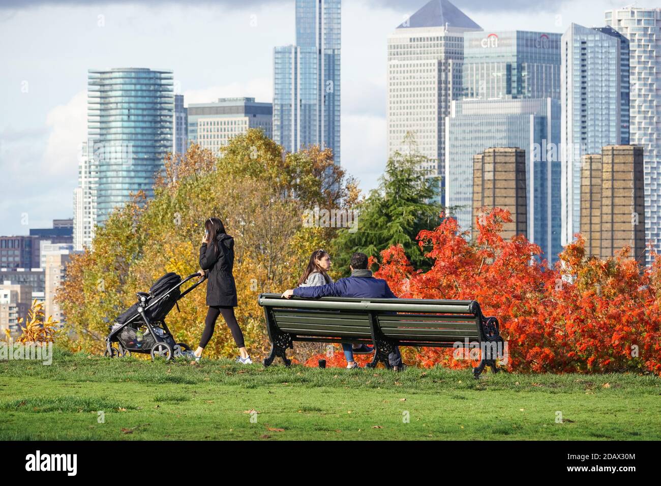 Le persone che godono della vista di Canary Wharf da Greenwich Park a Londra, Inghilterra, Regno Unito, Regno Unito Foto Stock