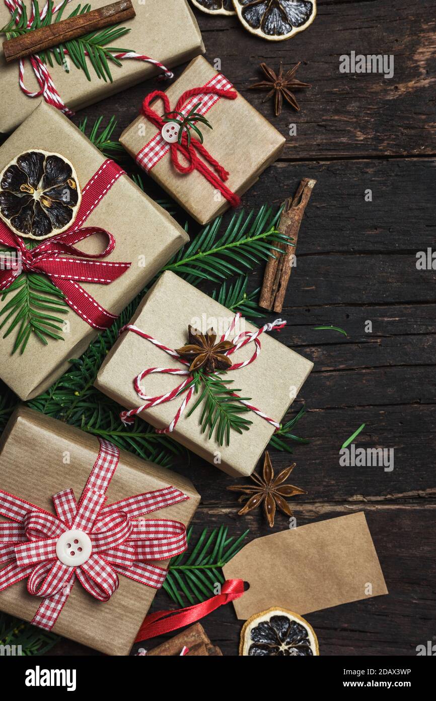 Biglietto d'auguri natalizio con diverse confezioni regalo su sfondo rustico in legno. Vista dall'alto con spazio per la copia. Foto Stock