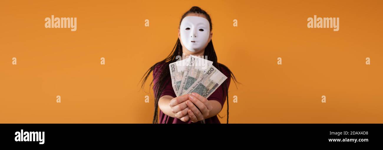 Cornice panoramica. Note cartacee tenute in mano. Un giovane adulto tiene in mano i contanti con le dita. Mani tese davanti a me. Trecce africane. Foto Stock