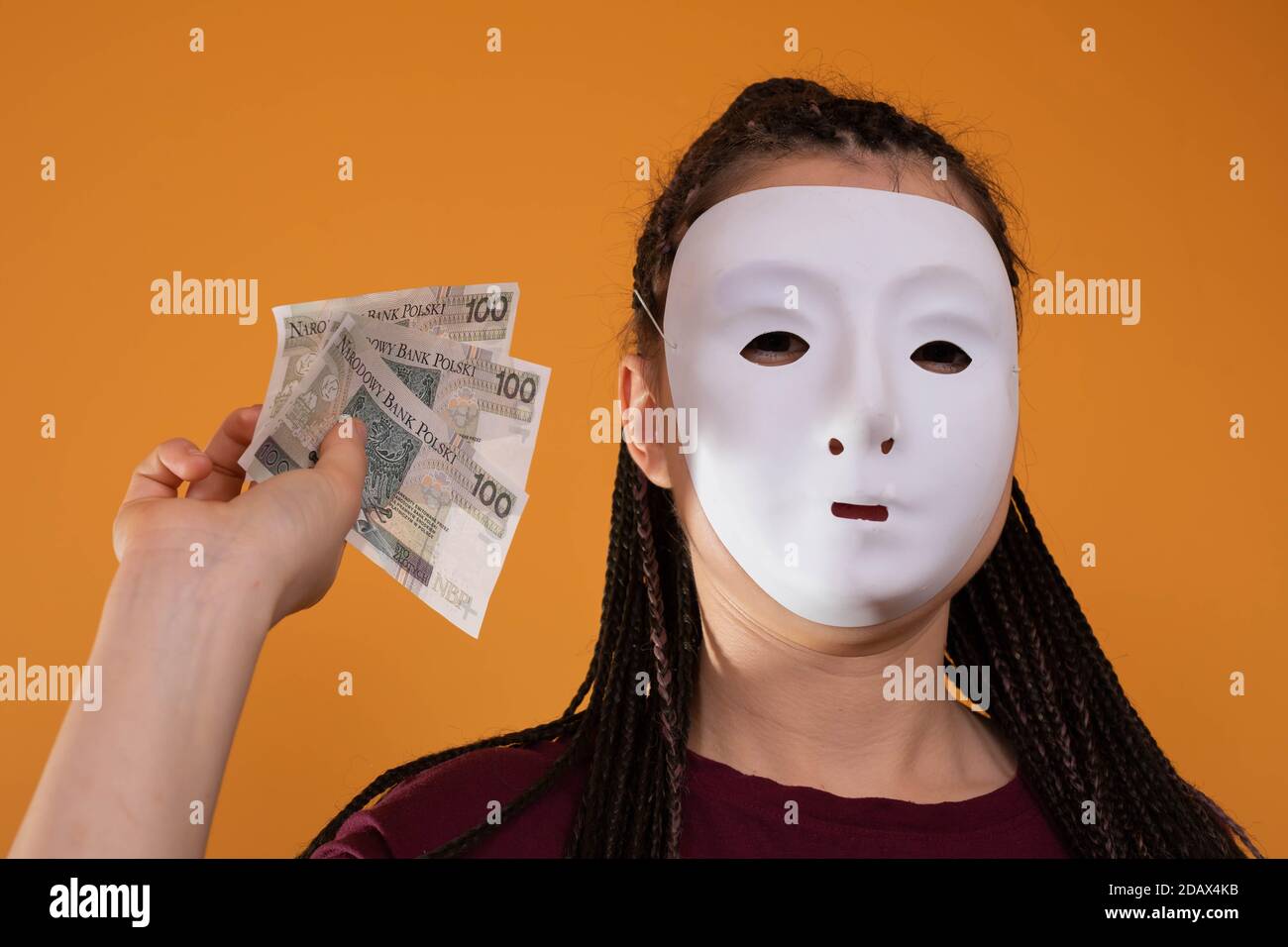 Note cartacee tenute in mano. Un giovane adulto tiene in mano i contanti con le dita. Mani tese davanti a me. Trecce africane. Foto Stock