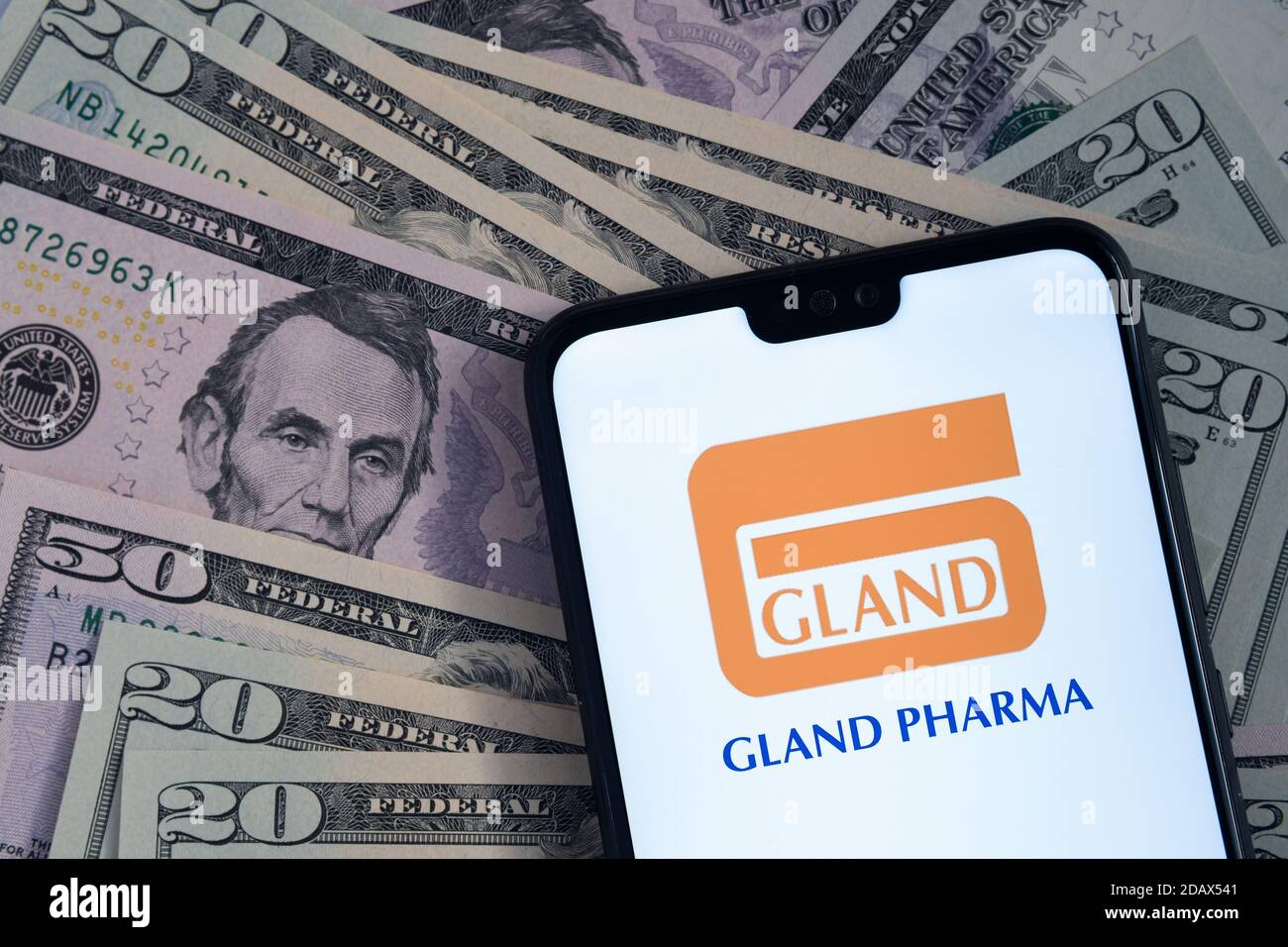 Stafford / Regno Unito - Novembre 15 2020: Logo della società Gland Pharma Limited visto sullo schermo dello smartphone, messo sulle bollette del dollaro. Foto Stock