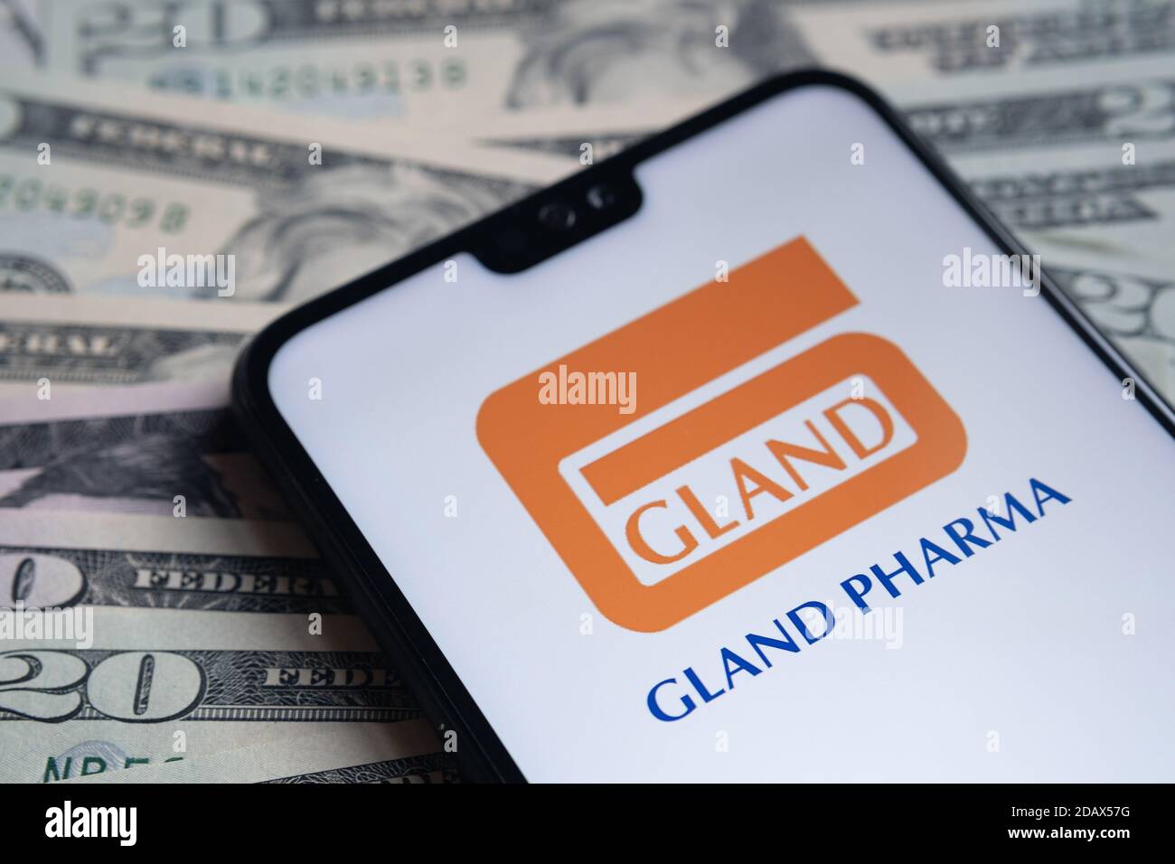 Stafford / Regno Unito - Novembre 15 2020: Logo della società Gland Pharma Limited visto sullo schermo dello smartphone, messo sulle bollette del dollaro. Foto Stock