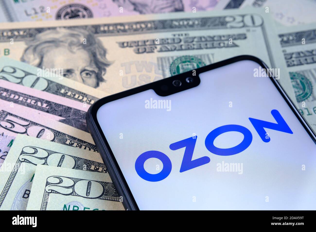 Stafford / Regno Unito - Novembre 15 2020: Ozon e-commerce logo aziendale visto sullo schermo dello smartphone, messo su bollette del dollaro. Concetto per gli initi Foto Stock