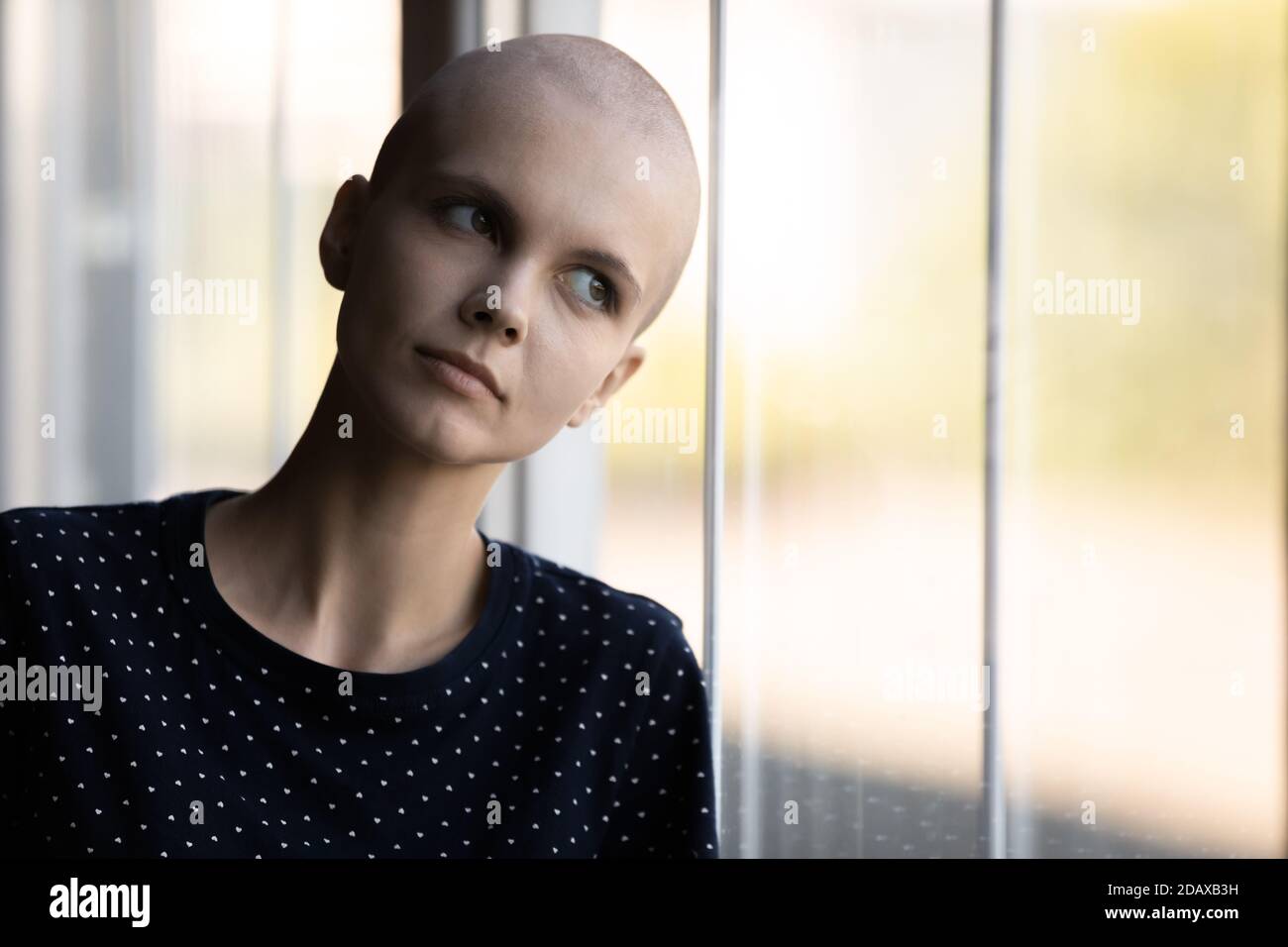 Paziente oncologico donna sconvolto stanco della terapia in piedi dalla finestra Foto Stock