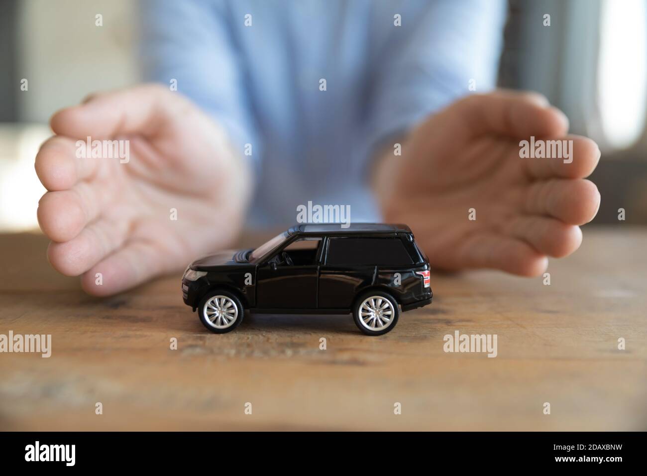 Assicuratore che protegge auto con le mani, concetto di servizi di copertura di assicurazione auto Foto Stock