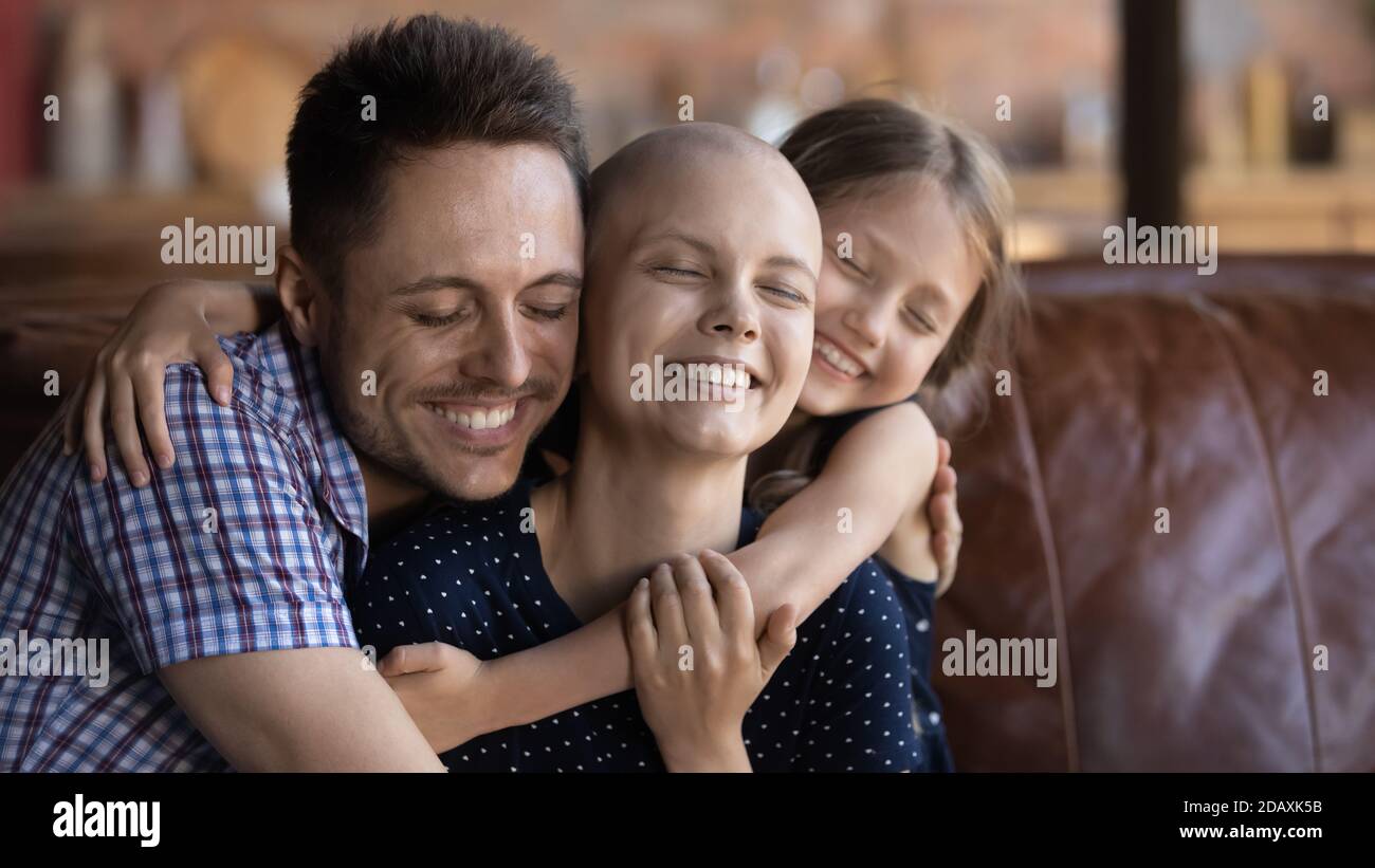Marito papà e figlia coccolando mamma moglie lotta contro il cancro Foto Stock