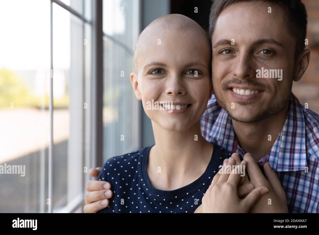 Il marito e la moglie speranzosi hanno diagnosticato con il cancro abbracciando dalla finestra Foto Stock