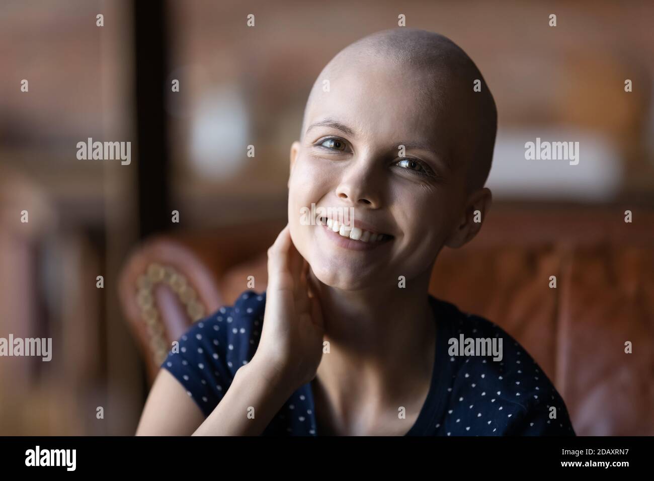 Motivata giovane donna cancro paziente guardando la macchina fotografica con sorriso Foto Stock